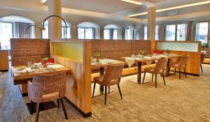 a restaurant with tables and chairs in a room at Hotel DreiSonnen in Serfaus