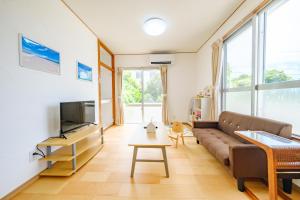 a living room with a couch and a tv at ふんわり in Miyakojima