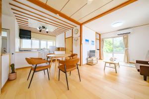 a kitchen and living room with a table and chairs at ふんわり in Miyakojima