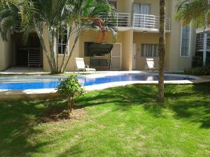una piscina frente a una casa con palmeras en Pura Vida Condo, en Tamarindo