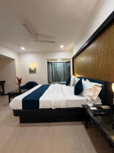 a large bedroom with a large bed and a desk at hotel royal highness in Ahmedabad