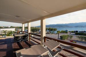 a porch with chairs and a table and a view of the water at Mobile Homes Krk Silo in Šilo