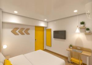 a room with a bed and a desk and a tv at Bloom Hotel CMH Road Indiranagar in Bangalore +15 photos