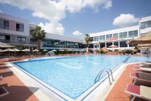 a large swimming pool in front of a building at Te Stela Resort & SPA in Tirana