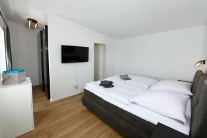 a bedroom with a bed with white pillows and a television at Apartment Schweriner Lieblingsplatz in Schwerin