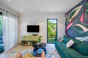 a living room with a green couch and a tv at Apartment Nest 20 in Ettenheim