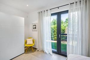 a bedroom with a window and a yellow chair at Apartment Nest 20 in Ettenheim