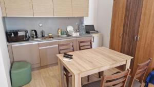 a small kitchen with a wooden table and a sink at Apart Complex Pontica - Sea View 20 in Chernomorets
