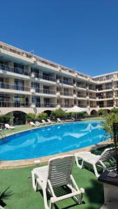 a swimming pool with two lawn chairs and a hotel at Apart Complex Pontica - Sea View 20 in Chernomorets