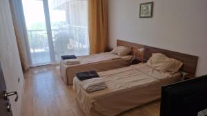 two beds in a room with a window at Apart Complex Pontica - Sea View 20 in Chernomorets