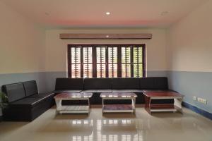a living room with a black couch and two tables at Manthali Park Inn in Rāmechhāp