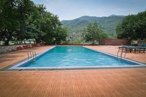 a large swimming pool with a table and mountains in the background at Manthali Park Inn in Rāmechhāp