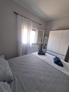 a bedroom with a large white bed with a window at VILLA HAWAii in Nea Moudania