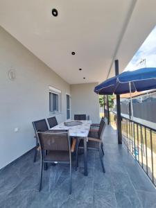 a dining room with a table and an umbrella at VILLA HAWAii in Nea Moudania