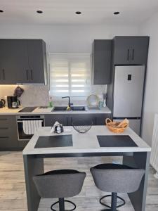 a kitchen with a kitchen island with two bar stools at VILLA HAWAii in Nea Moudania