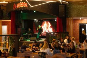 a group of people sitting in a restaurant with a fire at Te Stela Resort & SPA in Tirana