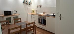 eine Küche mit einem Tisch, einer Spüle und einem Herd in der Unterkunft Downstairs6b WIEDERERÖFFNUNG IM JULI ! in Dipperz