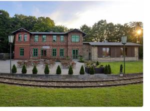 a large brick building with a park in front of it at Pension im historischem Bahnhof in Fehrbellin kein Frühstück in Fehrbellin