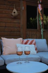 two wine glasses on a table in front of a couch at Het Leendernest in Leende
