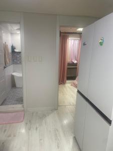 a white room with a refrigerator and a bathroom at 외국인여성전용게스트하우스 in Pup'yŏng-yŏk