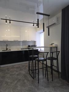 a kitchen with a table and chairs and a counter at Апартаменты возле отеля Украина in Chernihiv