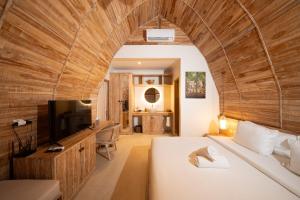 a bedroom with a large bed and a tv in a room at Omaneil Villa in Uluwatu