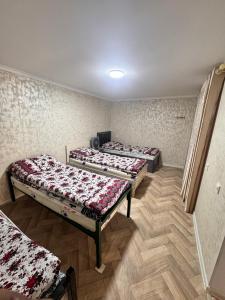 three beds are lined up in a room at Sharshara-Darvoz in Sangovy