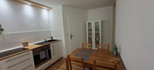 eine Küche mit Tisch und Spüle sowie ein Esszimmer in der Unterkunft Downstairs6b WIEDERERÖFFNUNG IM JULI ! in Dipperz