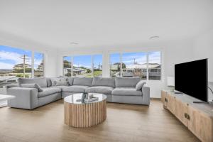 a living room with a couch and a tv at Callow Place 10 in Bermagui