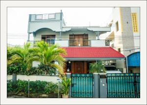 a house with a blue fence and palm trees at Manavididillu 4BHK DUPLEX VILLA in Rājahmundry