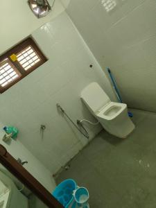 a bathroom with a white toilet in a stall at Manavididillu 4BHK DUPLEX VILLA in Rājahmundry +9 photos