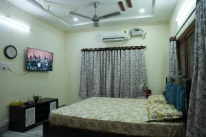 a bedroom with a bed and a window at Manavididillu 4BHK DUPLEX VILLA in Rājahmundry