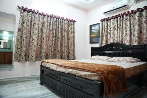 a bedroom with a large bed with curtains at Manavididillu 4BHK DUPLEX VILLA in Rājahmundry