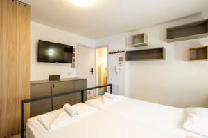 two beds in a room with a tv on the wall at Casa Riccobon 5 in Koper