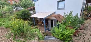 ein Garten mit einem Haus mit einem Dach in der Unterkunft Downstairs6b WIEDERERÖFFNUNG IM JULI ! in Dipperz + 9 Fotos