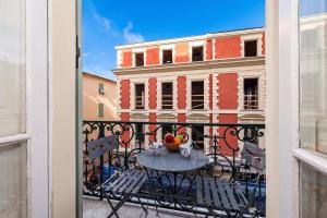 a table with a bowl of fruit on a balcony at Regina - Duplex in Heart of Menton - Happy Rentals in Menton