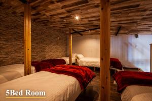 two beds in a room with wooden ceilings at 千葉地域ランキング1位獲得の贅沢な貸別荘全4棟 in Hota +51 photos
