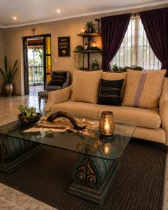 a living room with a couch and a table at Bushman Kraal Backpackers in Soweto