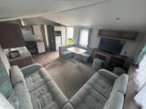 a living room with a couch and a television at Explorer45 in Lytchett Minster
