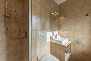 a bathroom with a toilet and a sink and a shower at Stammhaus Vetterer in Lana +23 photos