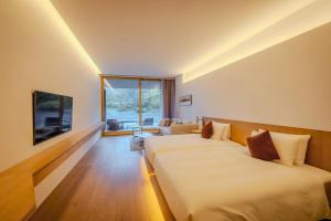 a hotel room with two beds and a couch at Muni Kyoto in Kyoto