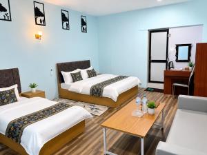 a hotel room with two beds and a table at Chautara Restro & Inn in Kathmandu