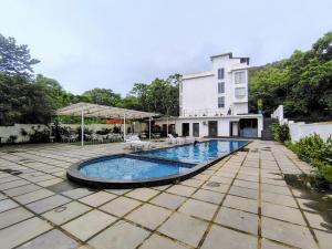 a swimming pool in front of a building at Goa Courtyard in Arpora