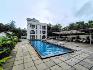 a swimming pool in front of a building at Goa Courtyard in Arpora