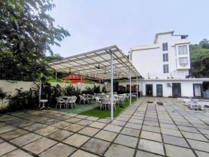 a patio with tables and chairs in front of a building at Goa Courtyard in Arpora