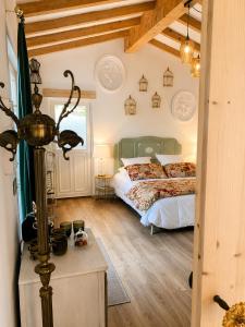 a bedroom with a bed and a wooden floor at Ô Dentelles in Vacqueyras