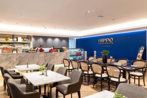 a restaurant with tables and chairs and a counter at Blue Hippo & Red Crocodile Hotel in Bangna