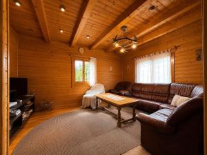 a living room with a leather couch and a table at Égéspatak Vendégház in Ghiduţ