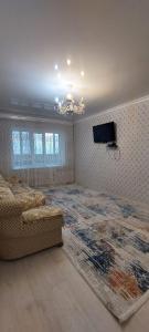 a living room with a large rug and a couch at Толе би 141А in Qyzylorda