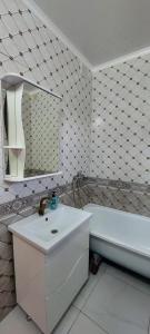 a bathroom with a sink and a tub and a mirror at Толе би 141А in Qyzylorda